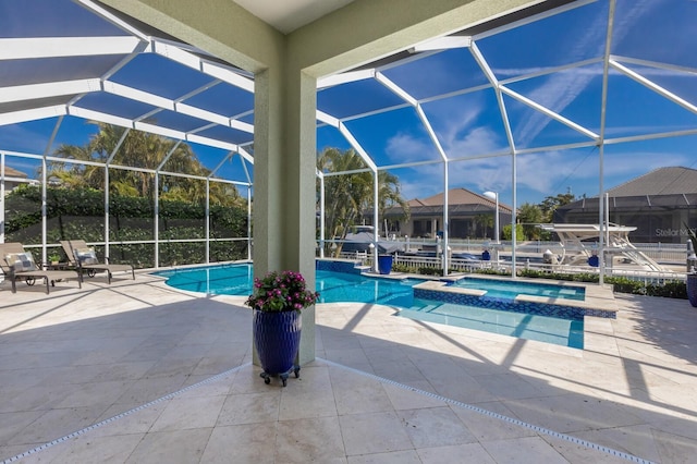 view of swimming pool with a pool with connected hot tub, a lanai, and a patio