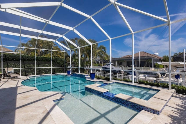 view of pool featuring a lanai, a patio area, a pool with connected hot tub, and fence