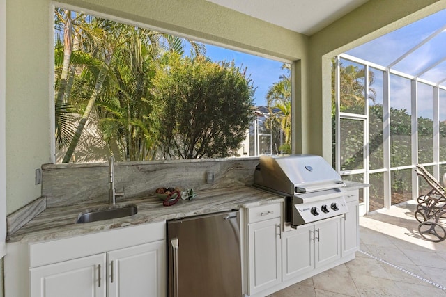 view of patio / terrace featuring glass enclosure, exterior kitchen, a sink, and area for grilling