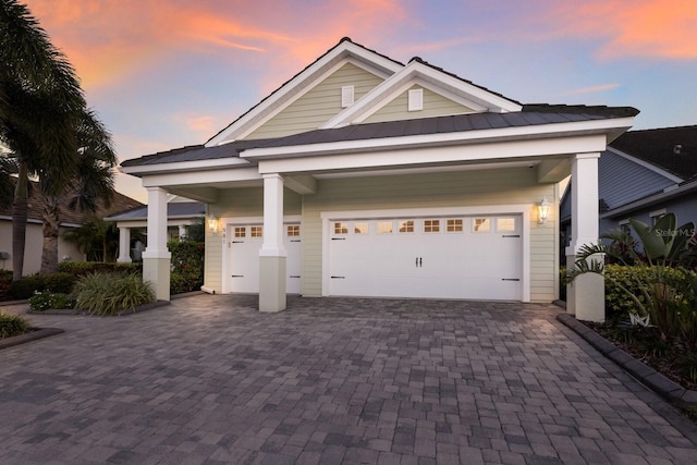 craftsman house featuring a standing seam roof, metal roof, decorative driveway, and a garage