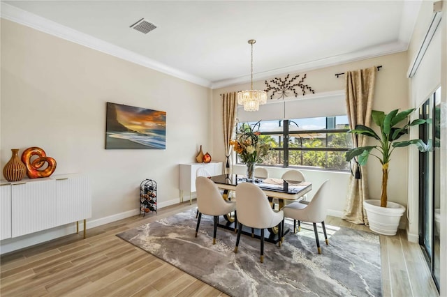 dining space featuring crown molding, baseboards, visible vents, and light wood-style floors