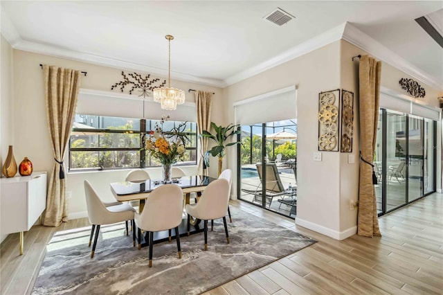 dining area with an inviting chandelier, crown molding, baseboards, and wood finished floors