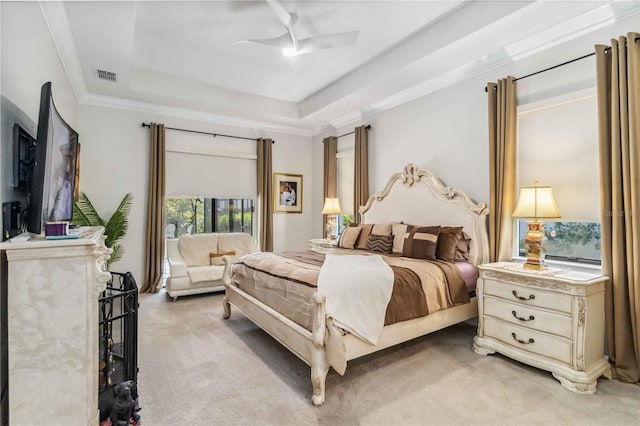 bedroom featuring ceiling fan, light colored carpet, visible vents, ornamental molding, and a raised ceiling