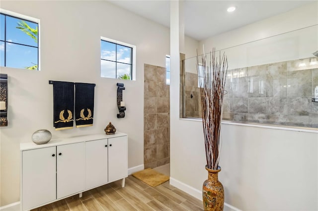 bathroom with wood tiled floor, baseboards, and a walk in shower