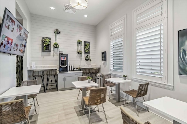 interior space with light wood-style floors, recessed lighting, visible vents, and wood walls