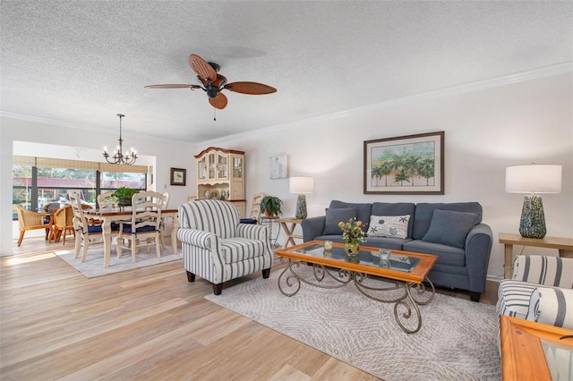 living room with a textured ceiling, light wood finished floors, ceiling fan with notable chandelier, and ornamental molding