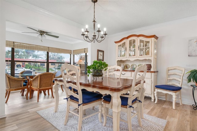 dining space featuring ornamental molding, light wood-type flooring, a textured ceiling, and ceiling fan with notable chandelier