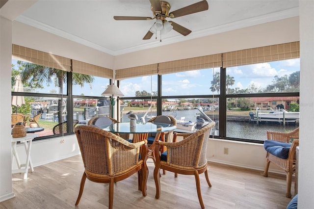 sunroom with a water view and a ceiling fan