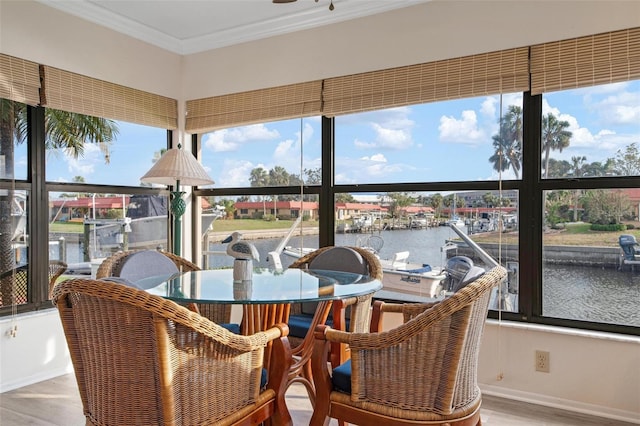 sunroom featuring a water view