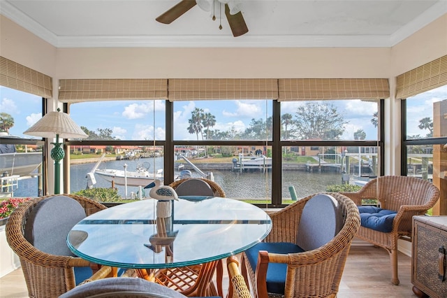 sunroom with a water view and a ceiling fan