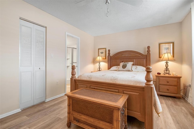 bedroom featuring light wood-style flooring, connected bathroom, baseboards, and a textured ceiling