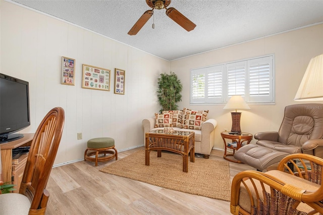 interior space featuring a textured ceiling, ceiling fan, and light wood finished floors