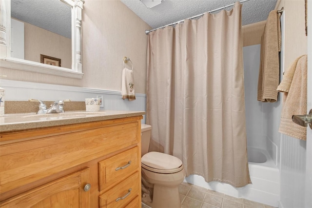 bathroom with toilet, tile patterned flooring, shower / bath combo with shower curtain, a textured ceiling, and vanity