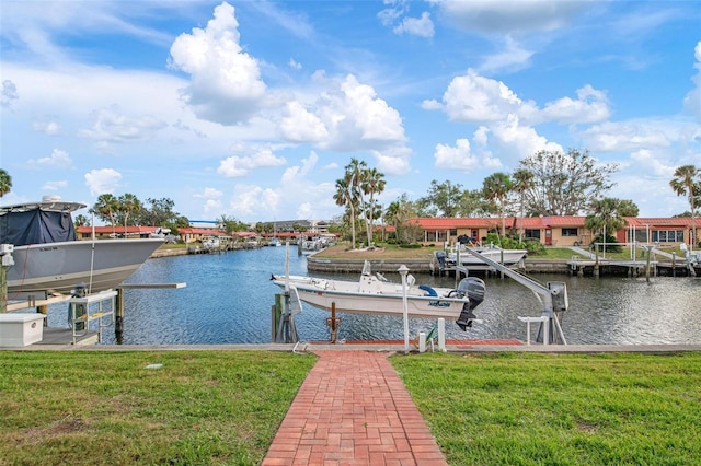 dock area with a water view, boat lift, and a yard