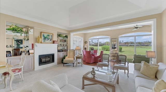 living room with light carpet, ceiling fan, a fireplace, and crown molding