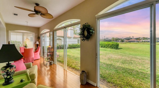 sunroom with ceiling fan, visible vents, and a wealth of natural light