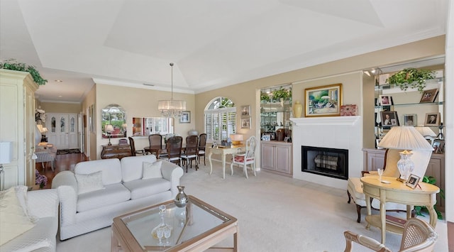 living area featuring light carpet, a fireplace, ornamental molding, a raised ceiling, and an inviting chandelier