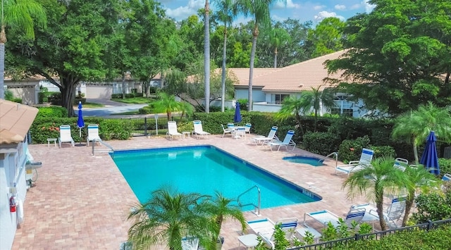 community pool featuring a patio, a community hot tub, and fence