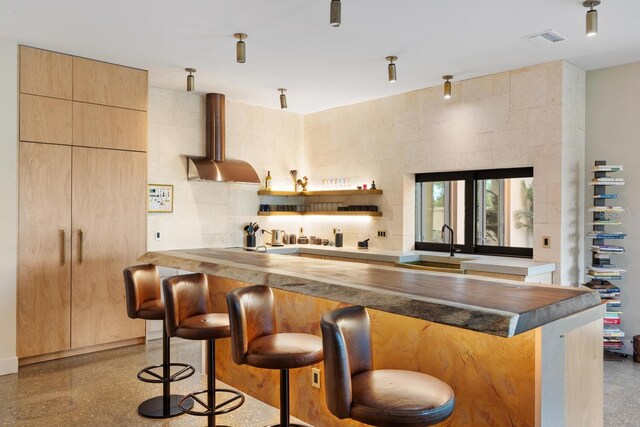 bar featuring wall chimney range hood, wet bar, visible vents, and a sink