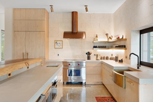 kitchen featuring light brown cabinets, a sink, exhaust hood, and designer range