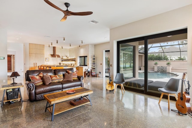 living area with ceiling fan, visible vents, and speckled floor