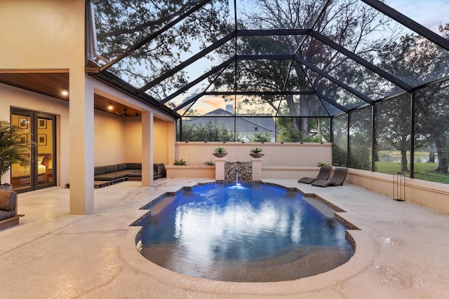 pool at dusk with a patio, glass enclosure, and an outdoor pool