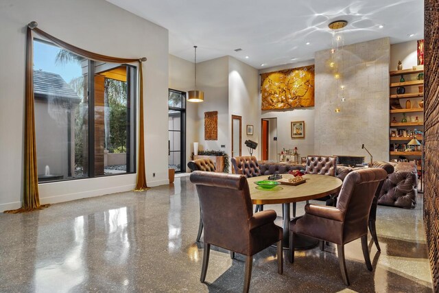 dining space with recessed lighting, a towering ceiling, and baseboards