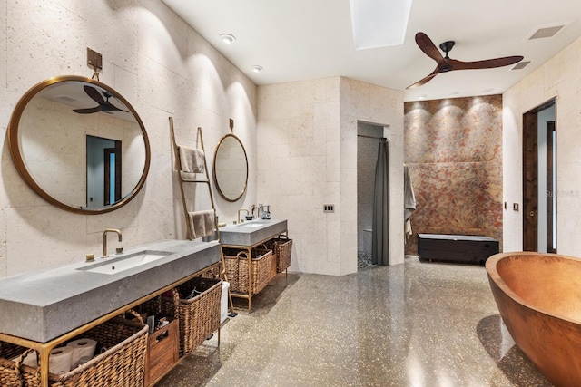 full bathroom with a ceiling fan, a soaking tub, two vanities, and a sink