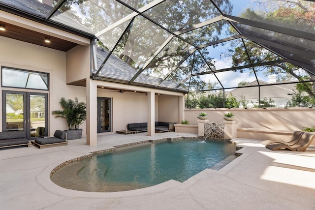 pool featuring a patio area, glass enclosure, a ceiling fan, and french doors