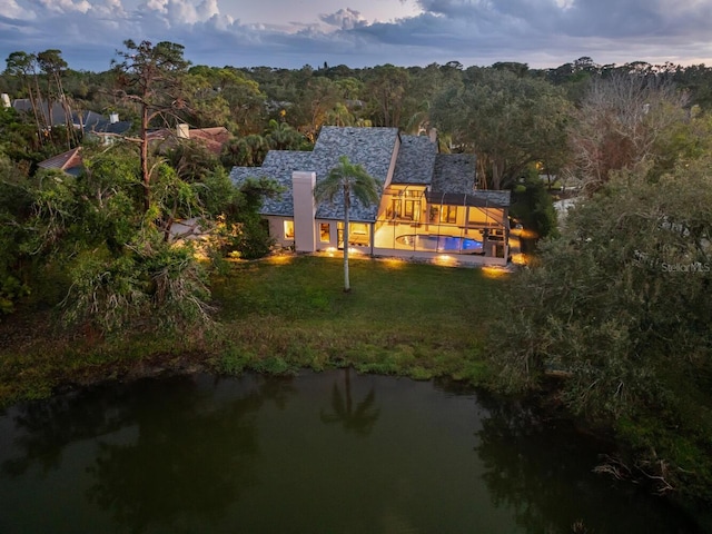 aerial view featuring a forest view and a water view