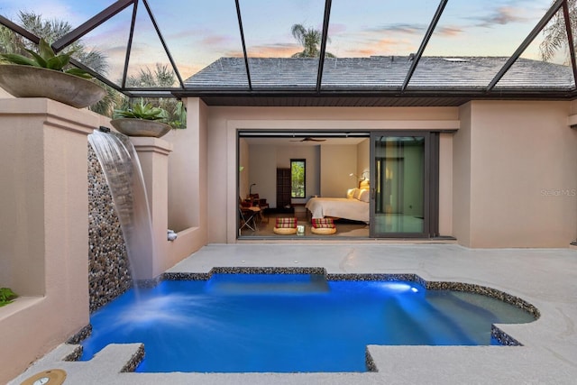 back of house featuring an outdoor pool, glass enclosure, a patio, and stucco siding