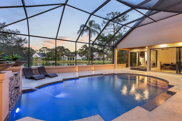 pool at dusk with glass enclosure, an outdoor pool, and a patio