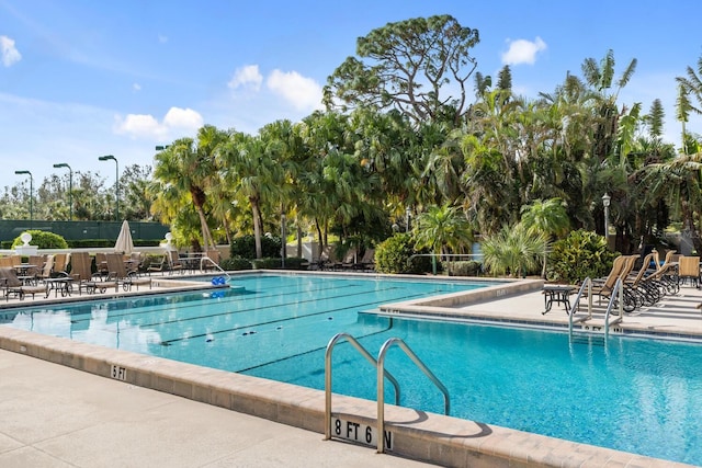 pool with fence and a patio