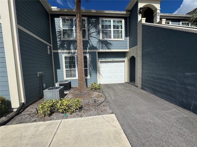 exterior space with a garage, central AC, and driveway