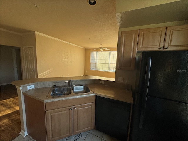 kitchen featuring ceiling fan, ornamental molding, a peninsula, black appliances, and a sink