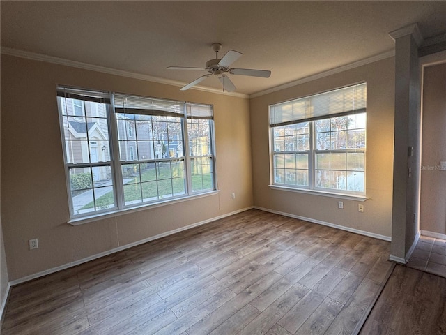 unfurnished room featuring baseboards, ceiling fan, wood finished floors, and crown molding