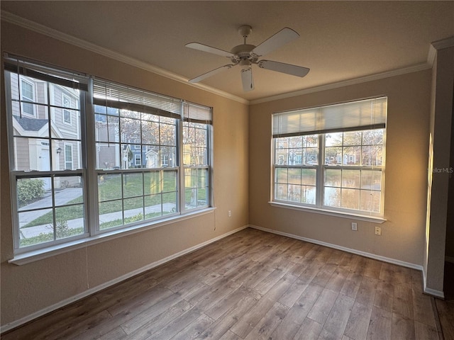 unfurnished room featuring baseboards, ceiling fan, ornamental molding, and wood finished floors