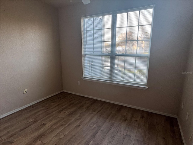 empty room featuring baseboards and wood finished floors