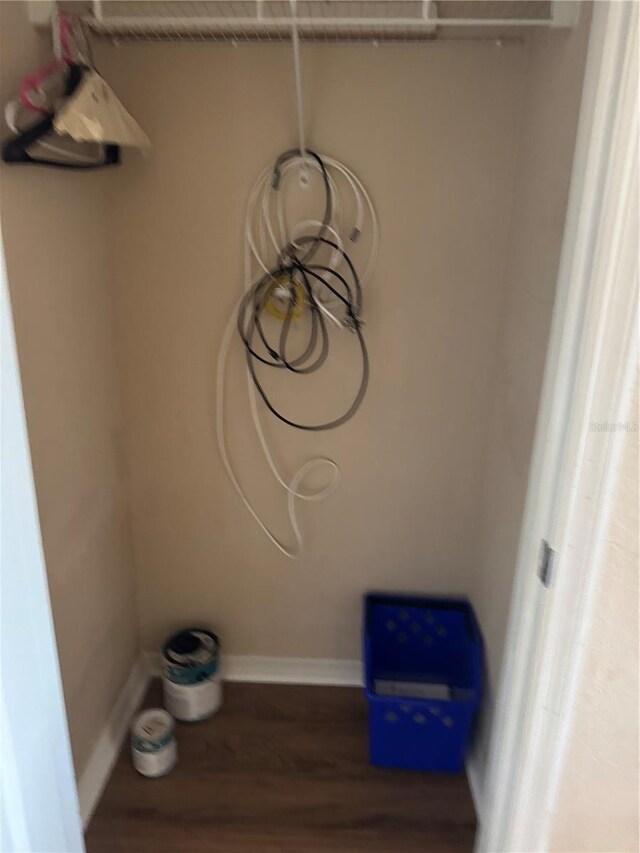 laundry area featuring baseboards and wood finished floors