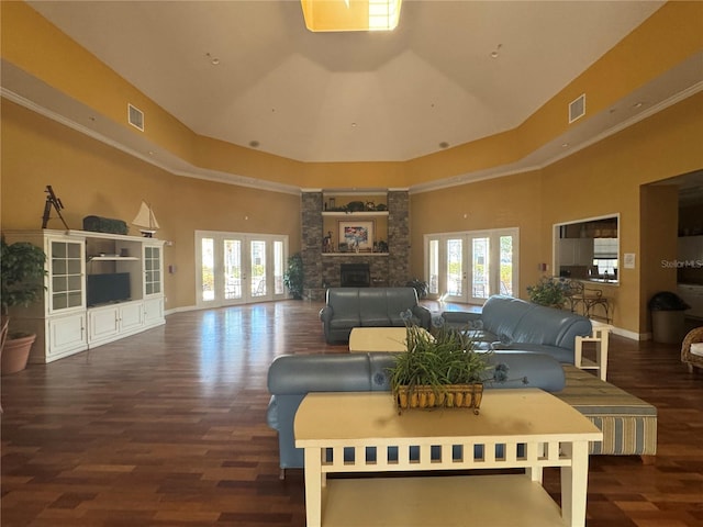 living area featuring a fireplace, visible vents, a raised ceiling, and french doors