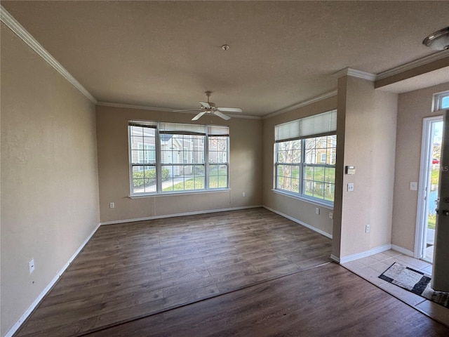 interior space with a ceiling fan, crown molding, baseboards, and wood finished floors