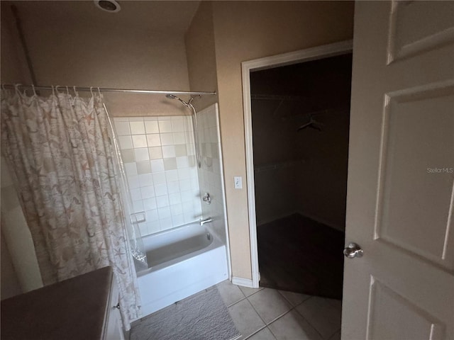 bathroom featuring a spacious closet, tile patterned flooring, and shower / tub combo with curtain