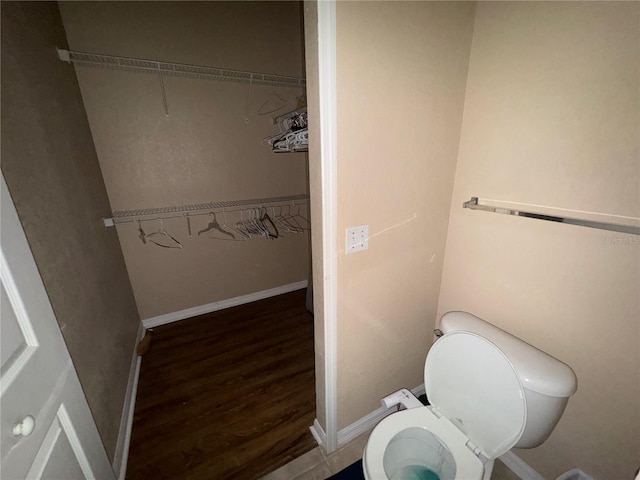 bathroom with baseboards, toilet, and wood finished floors