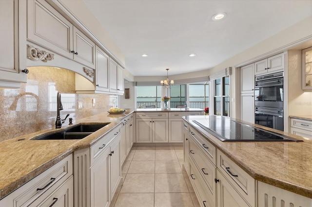 kitchen with light tile patterned floors, backsplash, a sink, light stone countertops, and black appliances