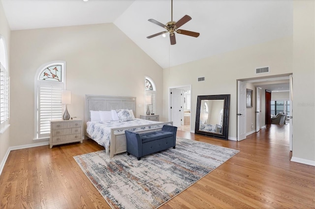 bedroom featuring high vaulted ceiling, wood finished floors, and visible vents