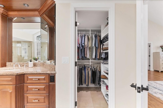 interior space with a walk in closet, vanity, and tile patterned floors