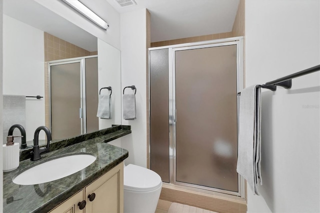 full bath with a stall shower, vanity, and toilet