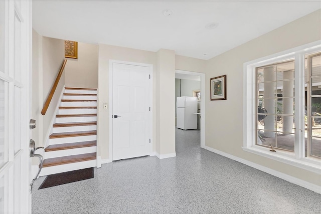 interior space featuring stairs, speckled floor, and baseboards