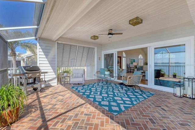 view of patio with glass enclosure, grilling area, and a ceiling fan