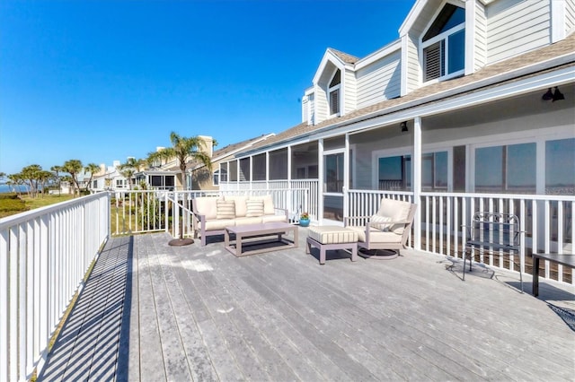 wooden deck with a sunroom and outdoor lounge area